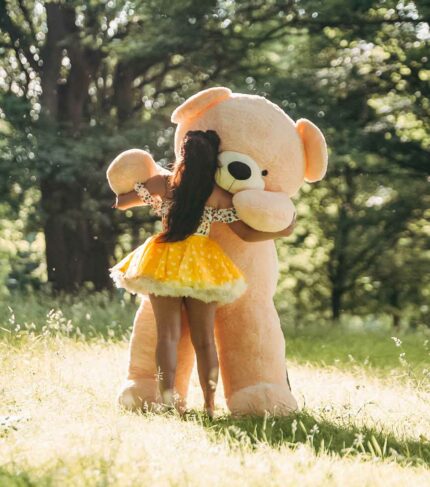 lady in yellow dress dancing with huge teddy bear