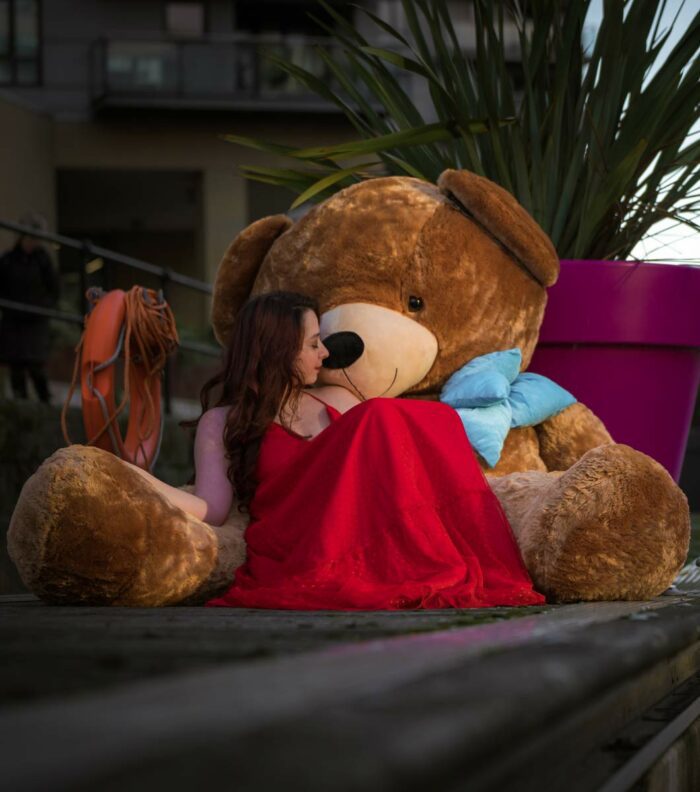 valentines romantic lady in red dress with giant bigted brown teddy bear