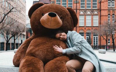 cute lady girl hugging giant lifesize brown teddy bear bigted