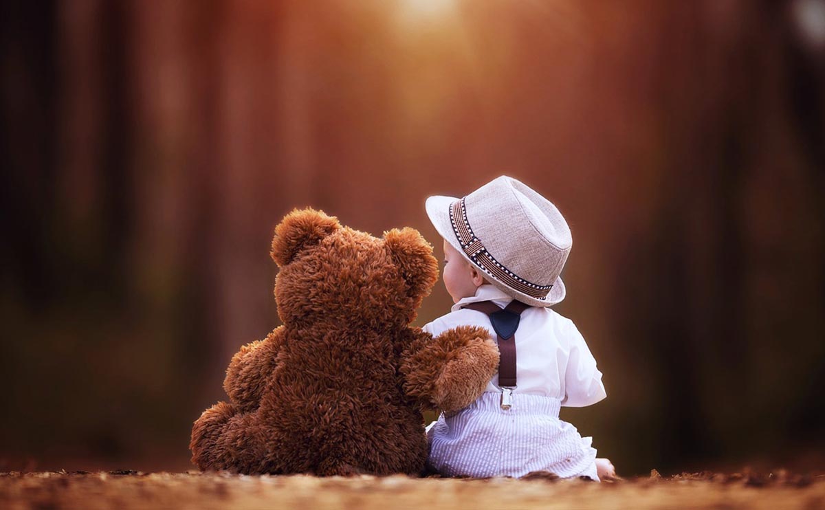 cute teddy bear hugging baby