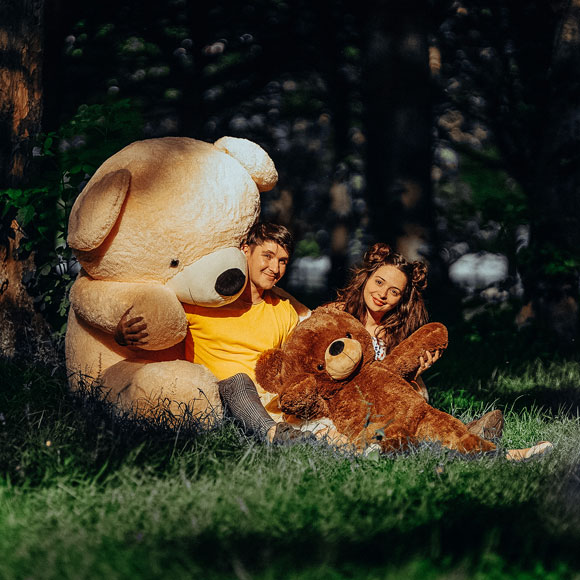 adorable couple with their teddy bears in forrest nature