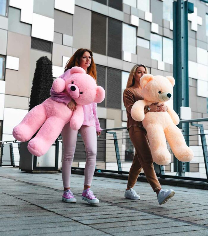 beautiful ladies holding pink and cream teddy bears