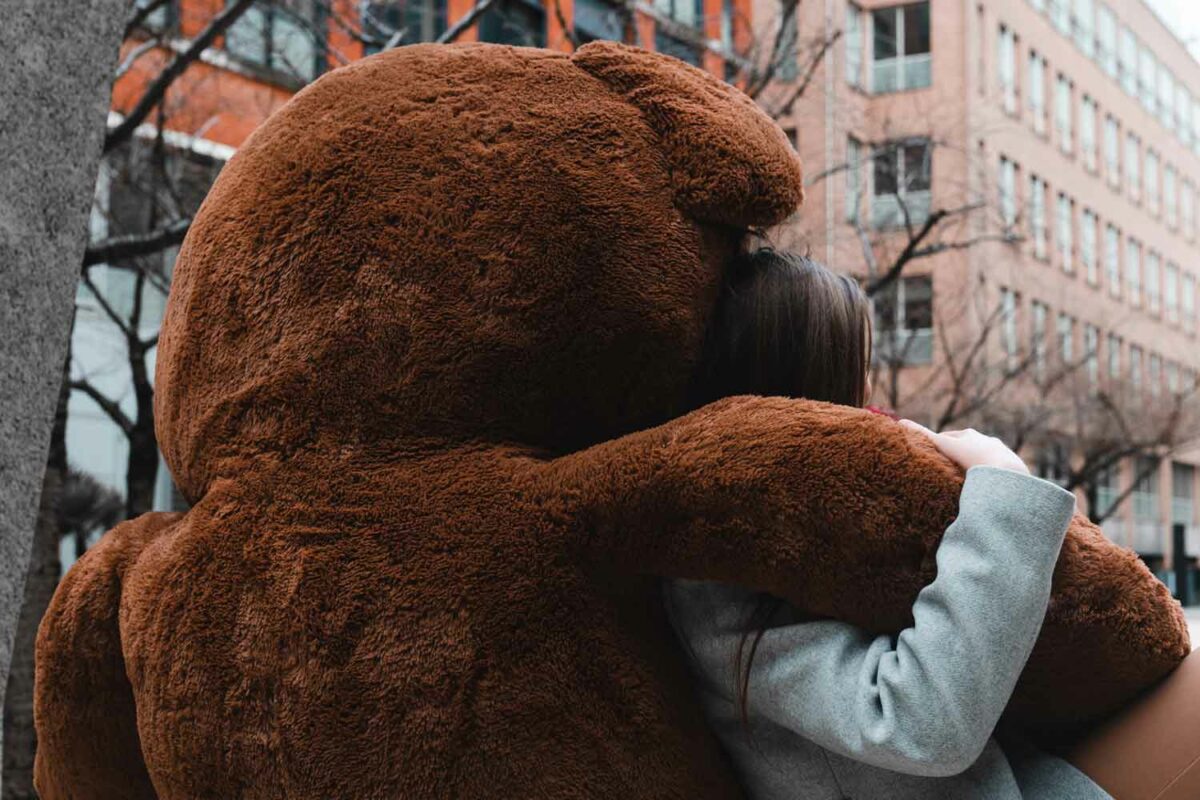 lady girl holding hugging arm of giant bigted teddy bear