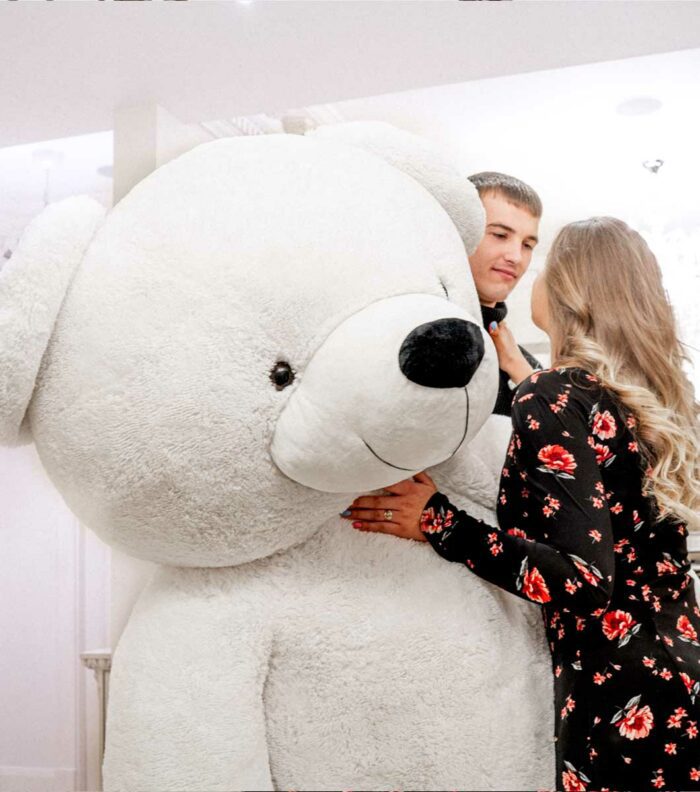 in love couple gifting giant white teddy bear