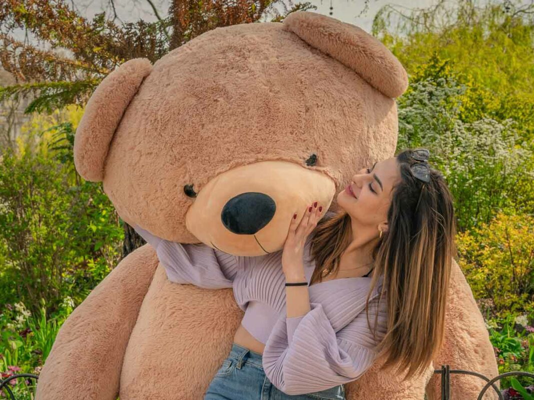 giant teddy bear hugged by young lady