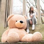 Girl with giant bigted teddy bear plush toy 2m light brown